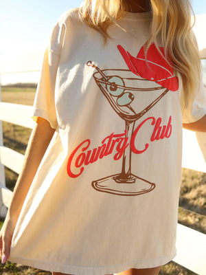 Person wearing a t-shirt with a martini glass design and 'Country Club' text.