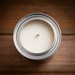 Candle in a glass jar on a wooden surface