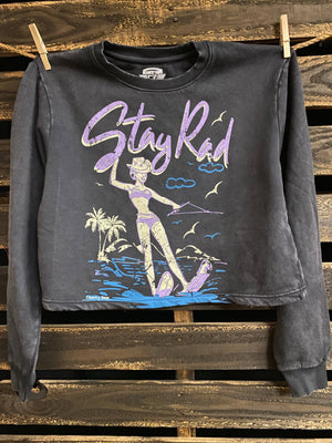 Black sweatshirt with 'Stay Rad' graphic design hanging on a wooden pallet.