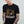Man wearing a black t-shirt with an eagle graphic and text on a plain background