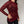 Red long-sleeve top with black pattern worn by a person on a plain background
