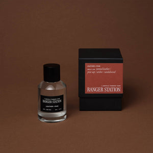 Ranger Station perfume bottle and packaging on a brown background