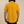 Person wearing a mustard yellow short-sleeve shirt on a beige background