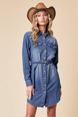 Woman wearing a blue denim dress and brown cowboy hat on a beige background