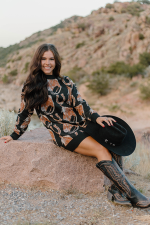 Woman sitting on a rock with a mountainous landscape in the background
