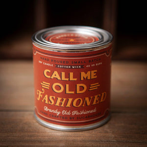 Candle canister labeled 'Call Me Old Fashioned' on a wooden surface