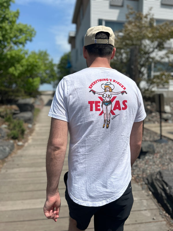 Man wearing a white t-shirt with a graphic design and text, walking outdoors.