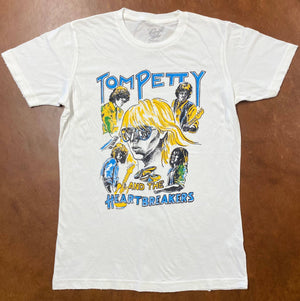 White t-shirt with 'Tom Petty and the Heartbreakers' graphic on a brown surface
