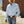 Man wearing a white shirt, blue jeans, and a yellow hat outdoors.