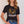 Woman wearing a black t-shirt with an eagle graphic and 'Desperado' text, paired with denim shorts.