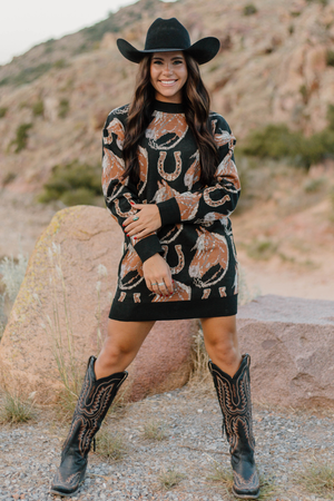 Woman wearing a patterned dress and cowboy boots in a desert setting
