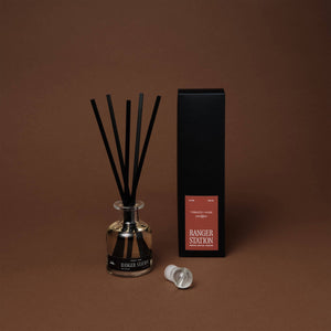 Diffuser with black sticks and packaging on a brown background