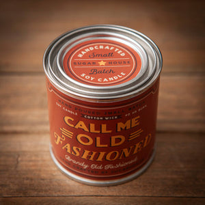 Candle tin labeled 'Call Me Old Fashioned' on a wooden surface